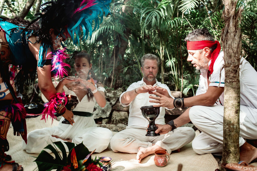 Momento íntimo de conexión emocional entre la pareja durante su boda espiritual en un cenote privado.