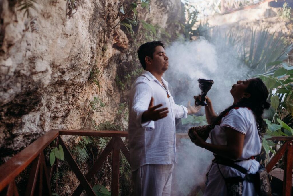 Scenic cenote with waterfall surrounded by lush jungle, ideal for a destination wedding in Quintana Roo