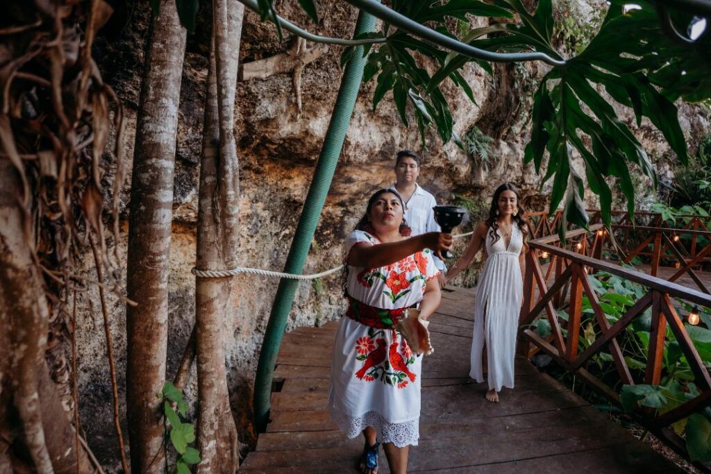 Couple receiving a sacred smoke blessing during a Mayan wedding ceremony inside a cenote