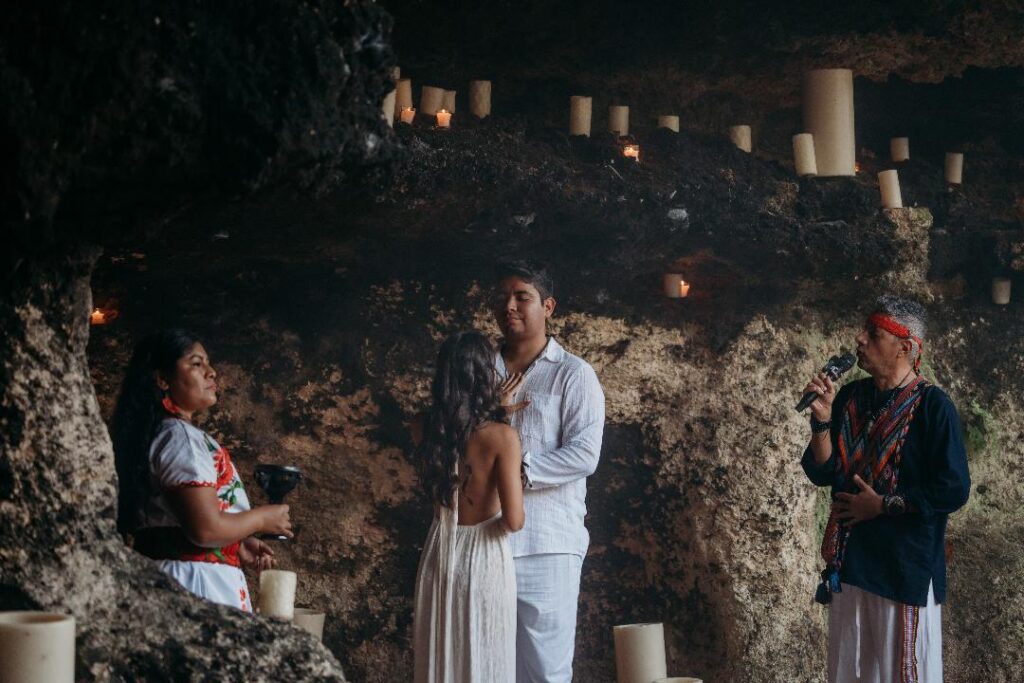 Traditional Mayan wedding altar with colorful ceremonial offerings arranged in a sacred mandala inside a cenote