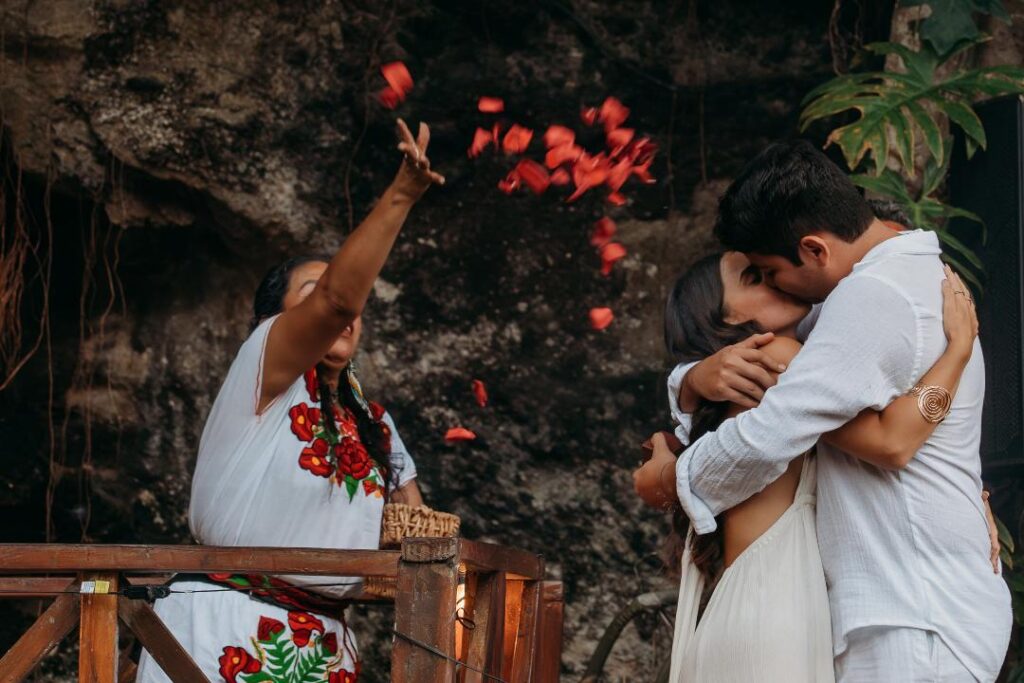 Couple embracing during a sacred cenote wedding ceremony surrounded by nature in Quintana Roo, Mexico