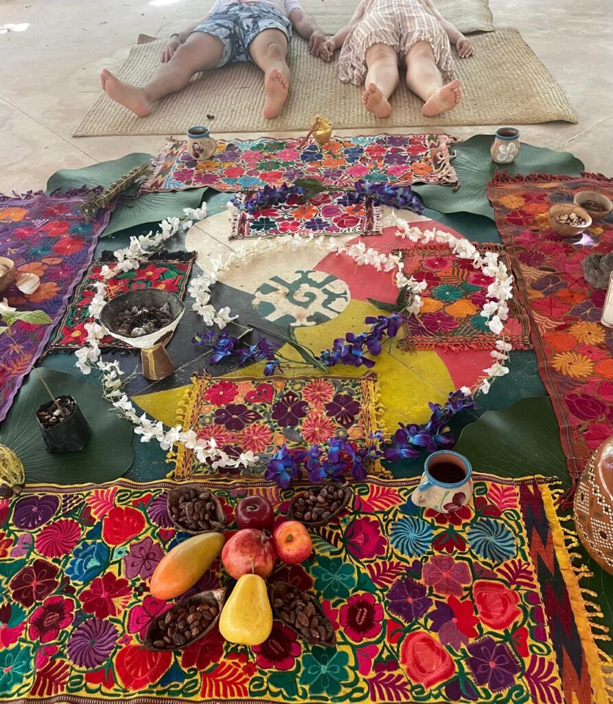 Pareja recostada en un mat en frente de una ofrenda/altar a los elementos