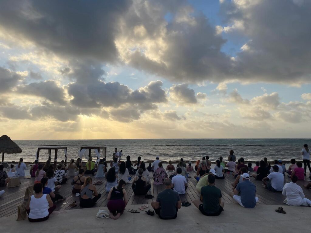 Grupo en meditacion al amanecer frente al oceano