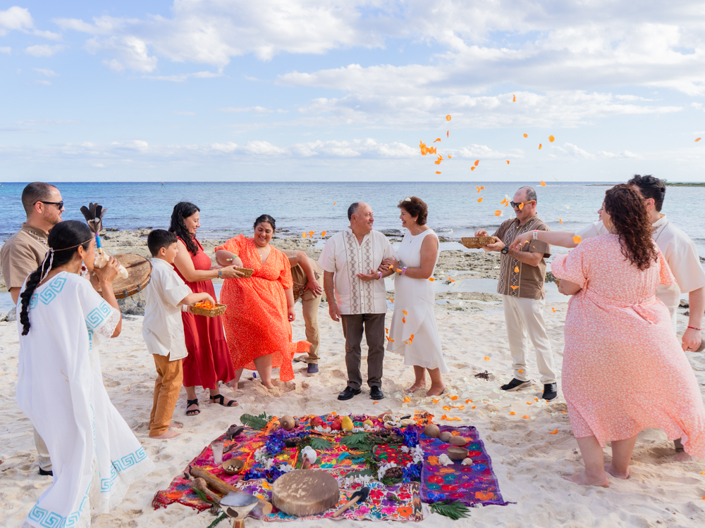 Guests in a circle on the sand during an anniversary celebration