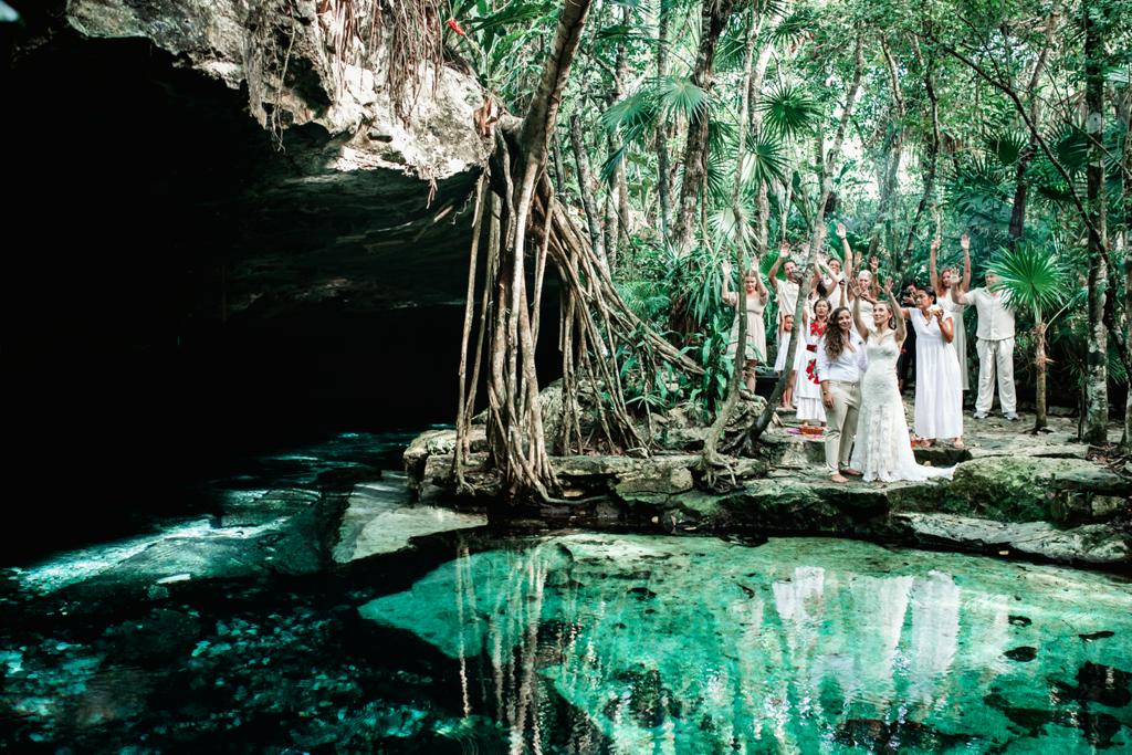 Group gathered beside a turquoise cenote in the jungle