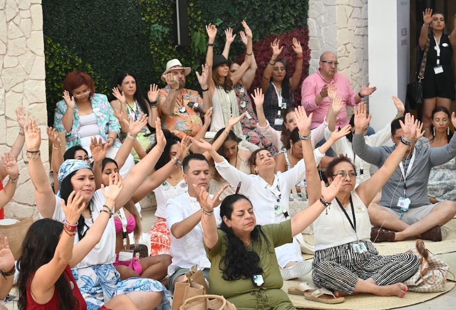 Group with arms raised during a wellness retreat activity