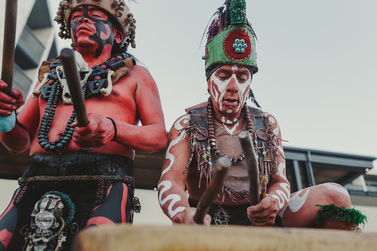 Dos músicos prehispánicos con la cara pintada y penachos de plumas