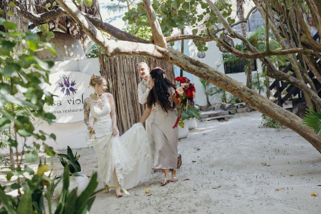 Newlyweds walking through lush tropical landscape after spiritual wedding in Riviera Maya