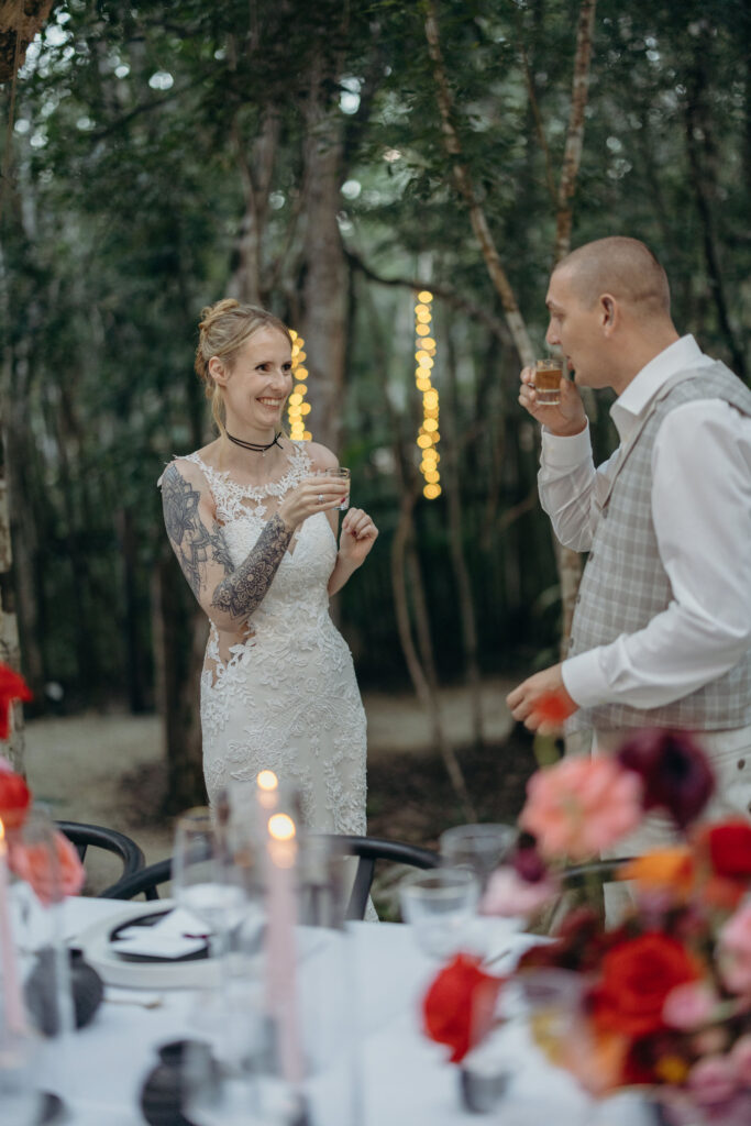 Bride and groom celebrating with champagne toast at intimate wedding reception in Tulum