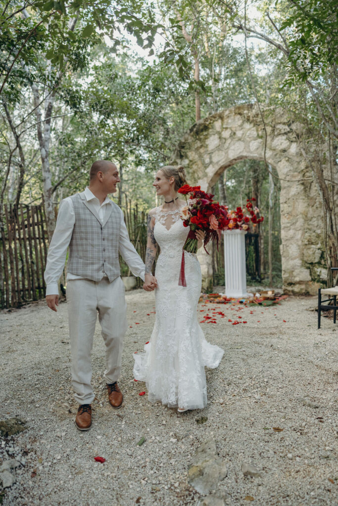 Newlyweds walking through tropical garden after spiritual wedding ceremony in Tulum