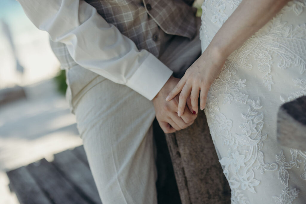 Close-up of bride and groom holding hands during destination wedding in Tulum Mexico