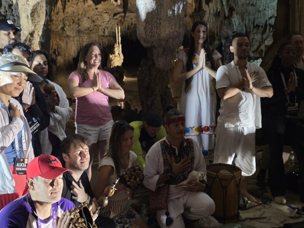 Guests and couple participating in sacred cenote ceremony in Riviera Maya cave setting