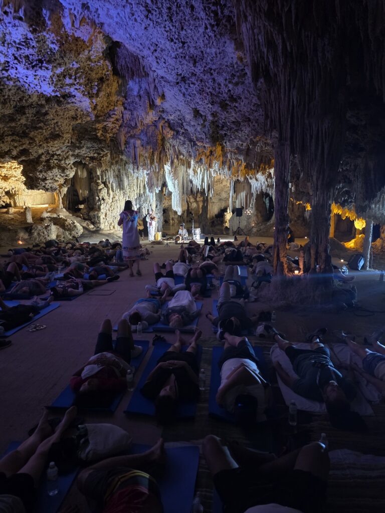 Wide view of group spiritual ceremony taking place inside natural cave in Riviera Maya